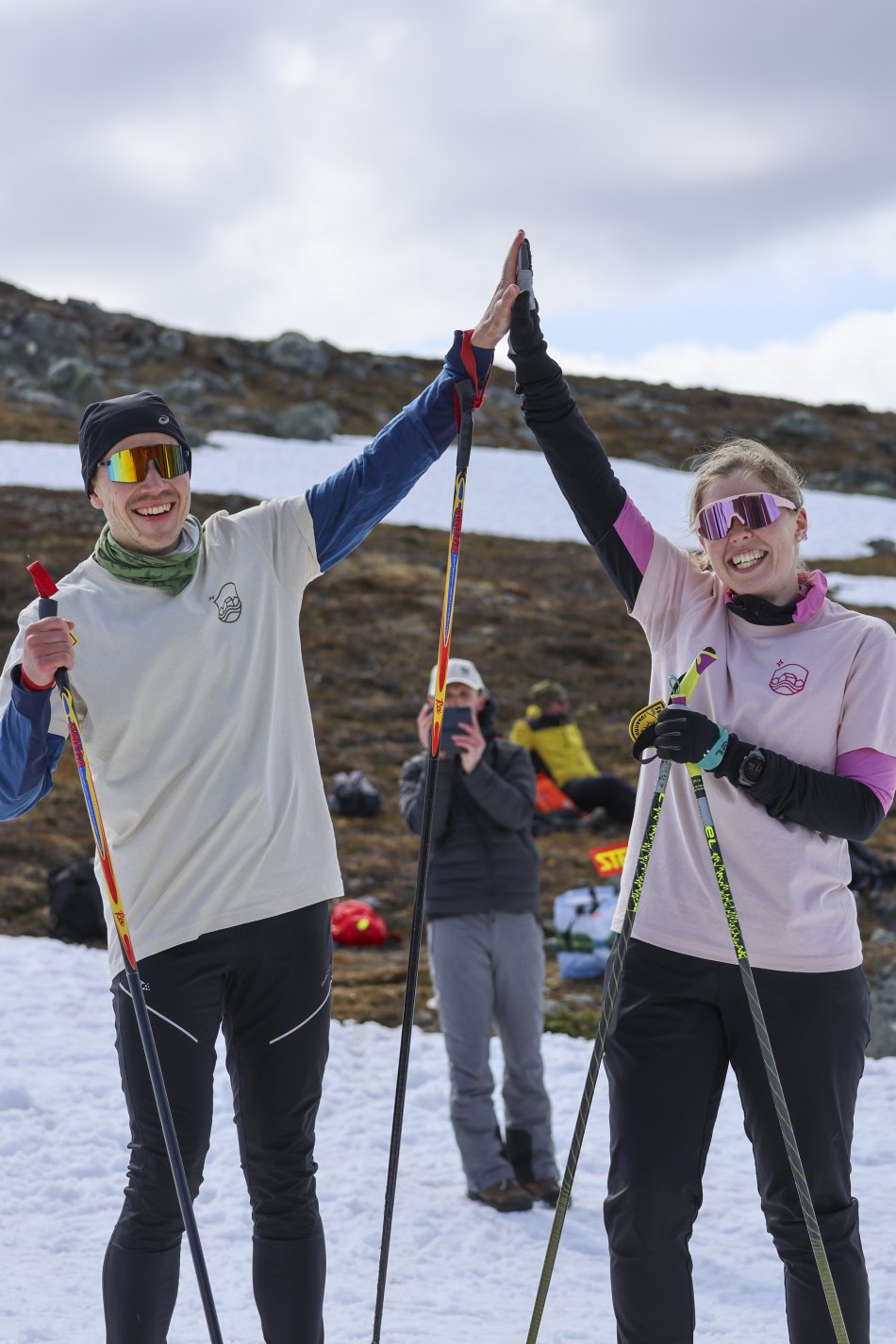 Iloinen nainen ja mies tekevät high five maaliin pääsyn jälkeen Kilpisjärven juhannushiihdoissa