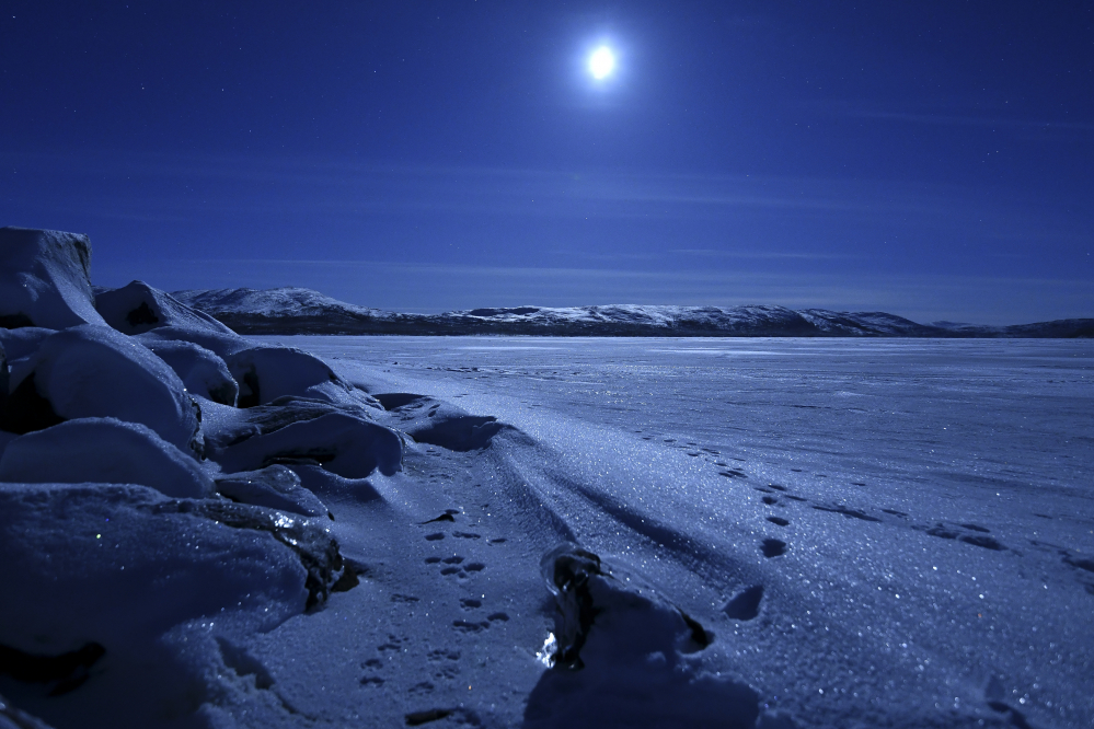 Kuu häikäisee Kilpisjärven jäällä joulukuussa