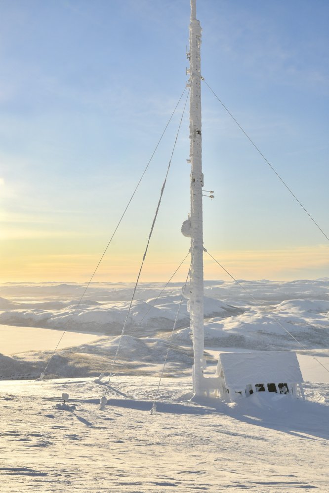 Saanan jäinen masto pakkaspäivänä tunturimaisema taustalla