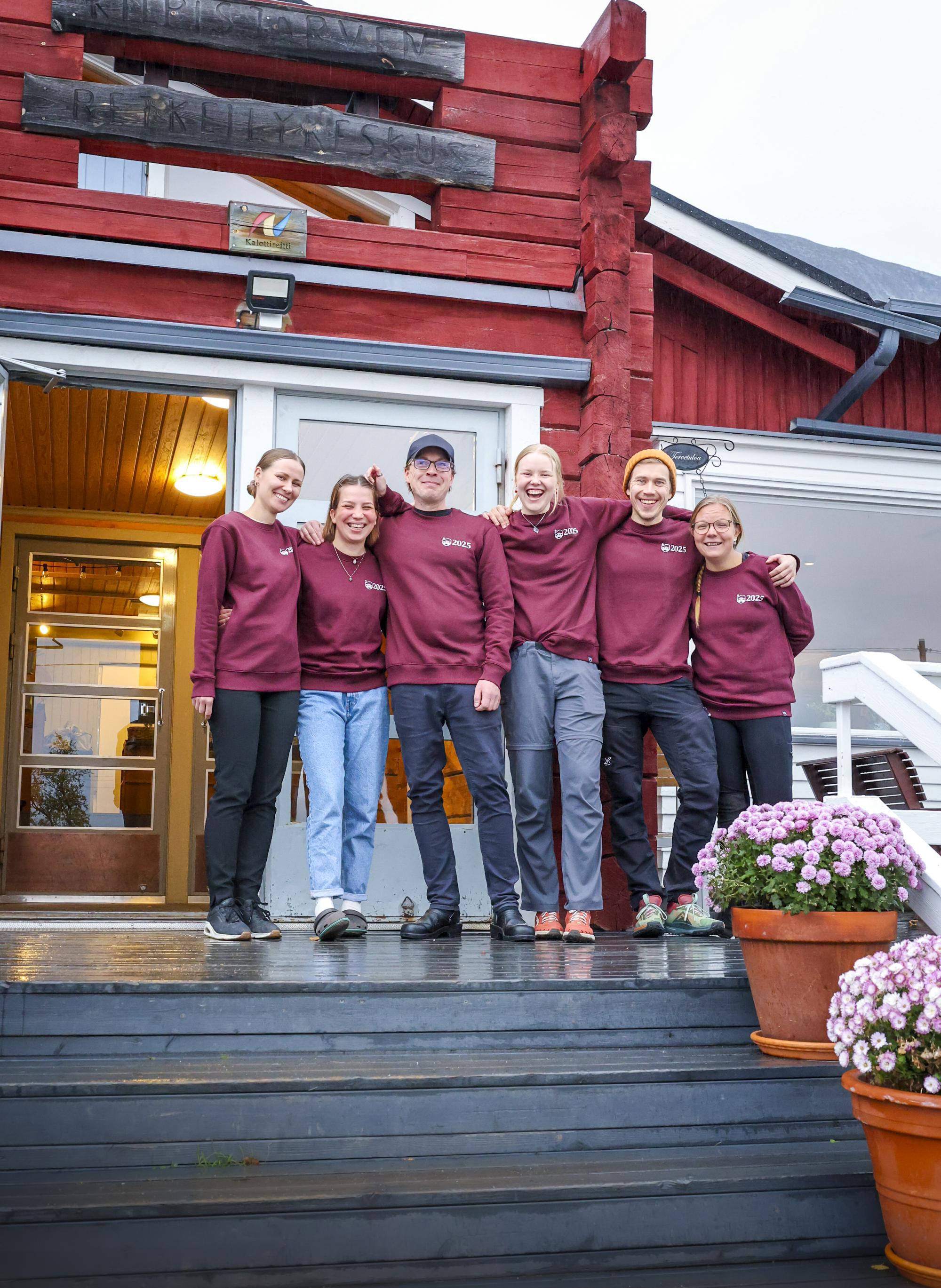 Kilpisjärven Retkeilykeskus henkilökunta portailla iloisena