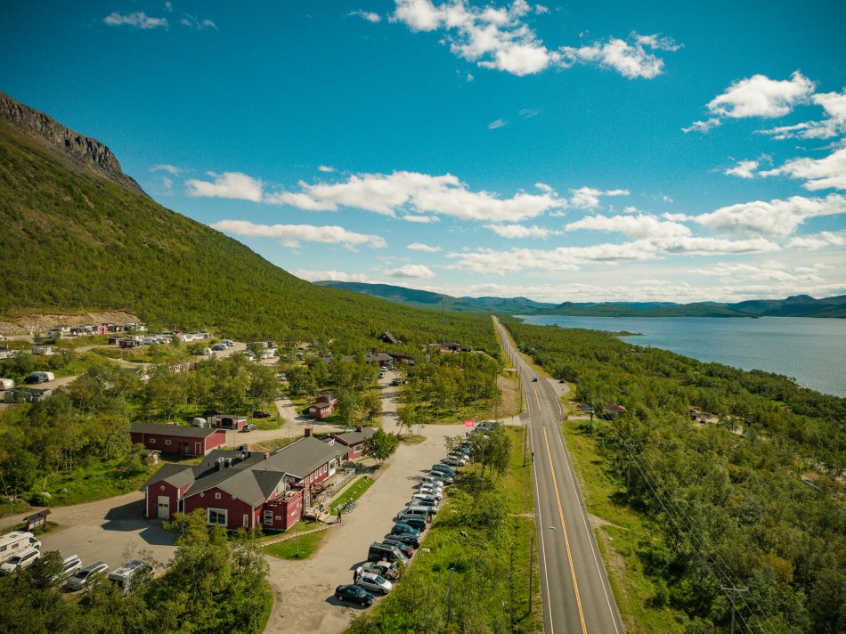 Caravan-alue Kilpisjärvellä kuvattuna ylhäältäpäin ja maisemaa Kilpisjärvelle kaamospäivän pastellinsävyisessä valossa.