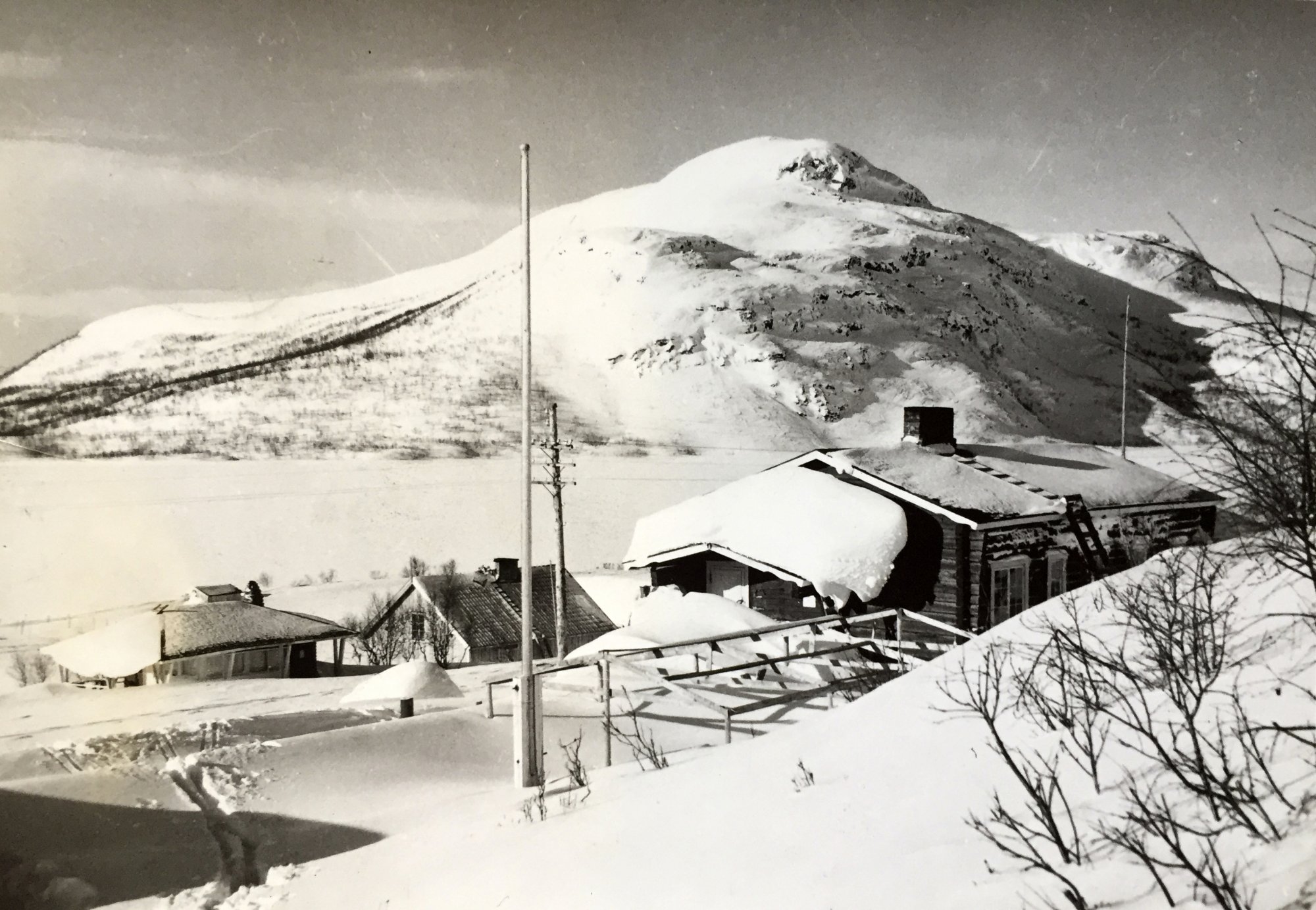 Vanha mustavalkoinen kuva kevättalvella Saanan rinteeltä kohti pikku-mallaa. Kuvan keskiössä Kilpisjärven Retkeilykeskus.